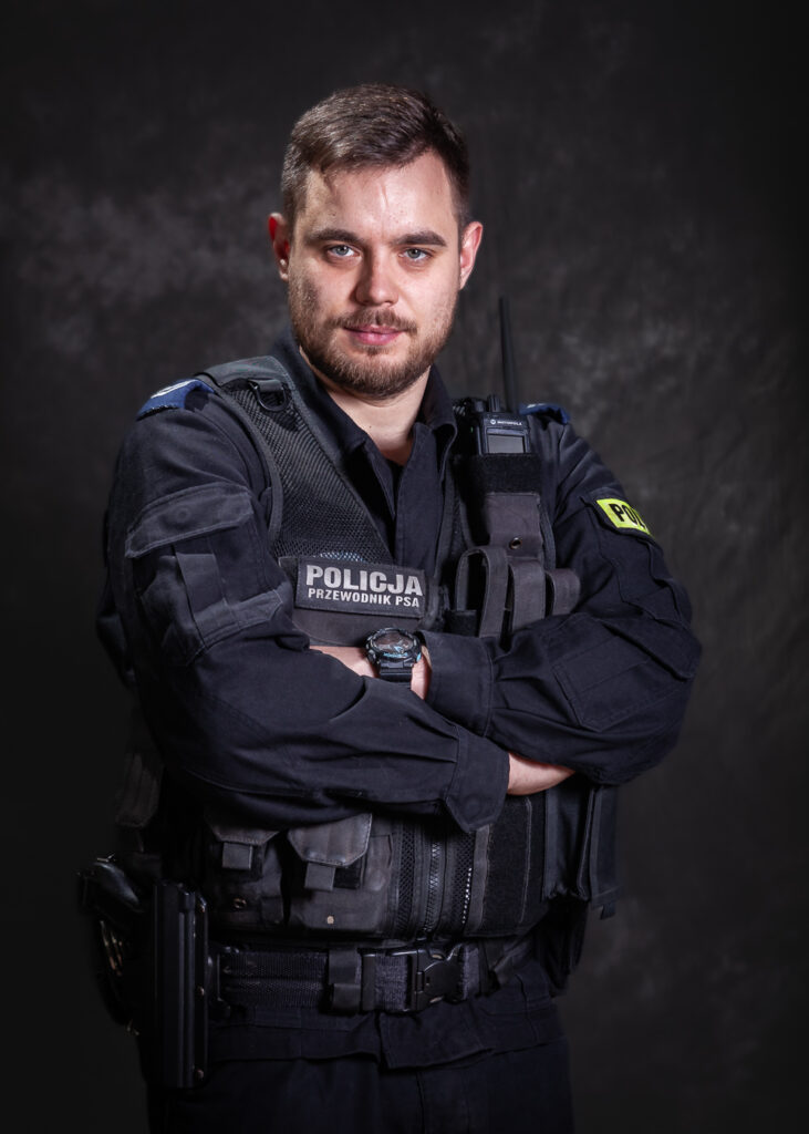 portret mundurowy, policja, policjant, mundur służbowy czarny bez czapki, kamizelka taktyczna