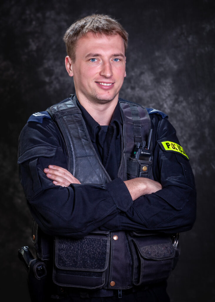 portret mundurowy, policja, policjant, mundur służbowy czarny bez czapki, kamizelka taktyczna