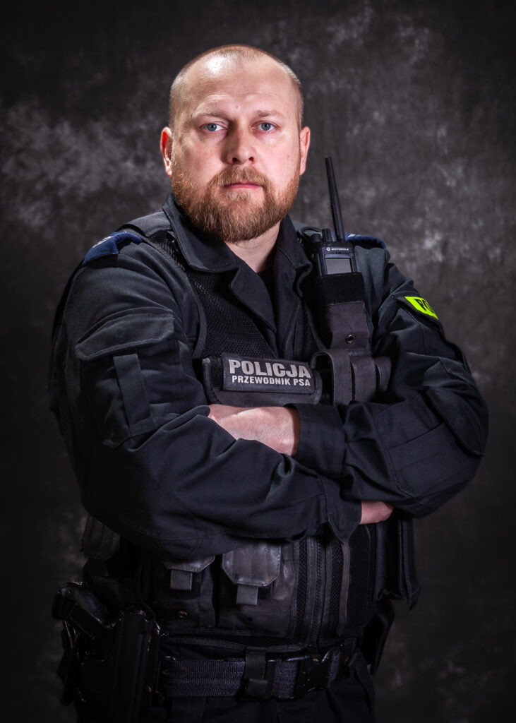 portret mundurowy, policja, policjant, mundur służbowy czarny bez czapki, kamizelka taktyczna