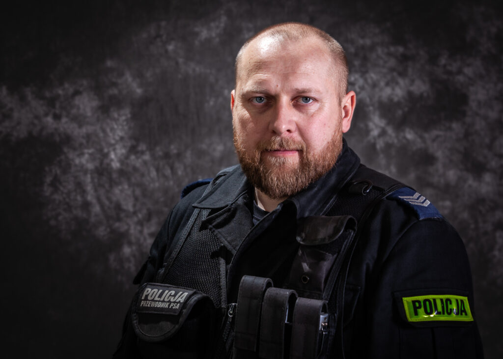 portret mundurowy, policja, policjant, mundur służbowy czarny bez czapki, kamizelka taktyczna