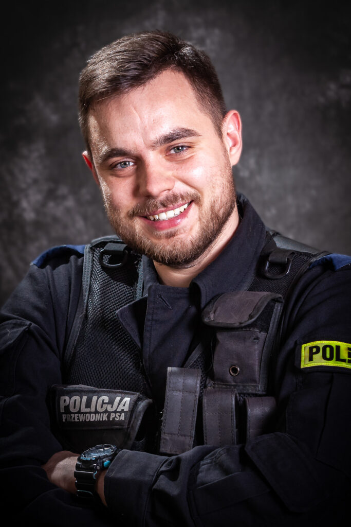 portret mundurowy, policja, policjant, mundur służbowy czarny bez czapki, kamizelka taktyczna