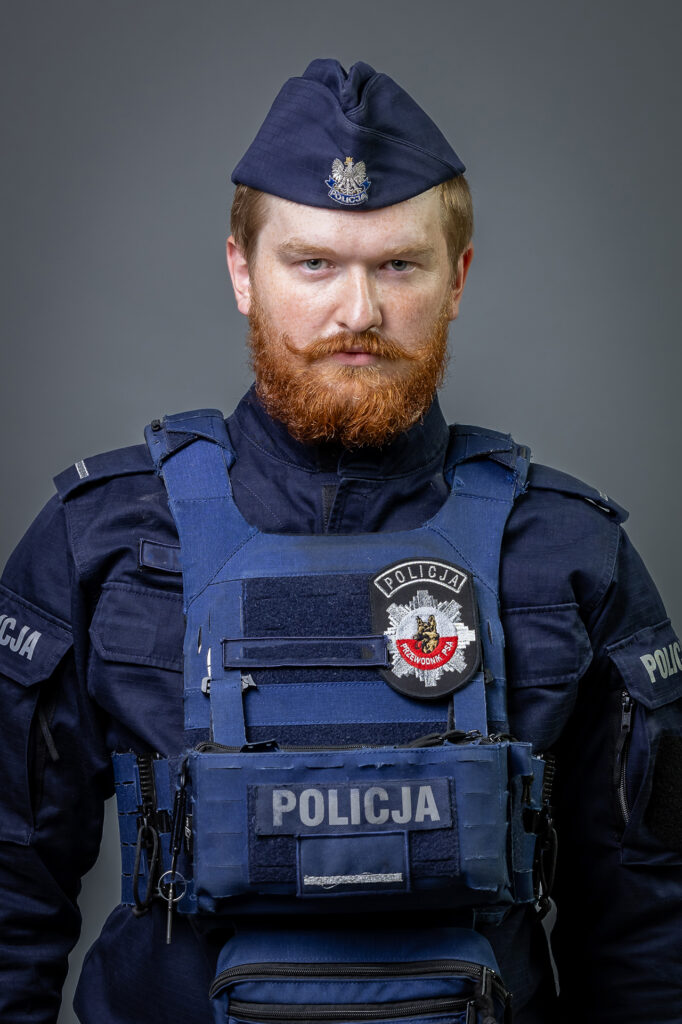 portret mundurowy, policja, policjant. mundur służbowy z czapką, kamizelka taktyczna