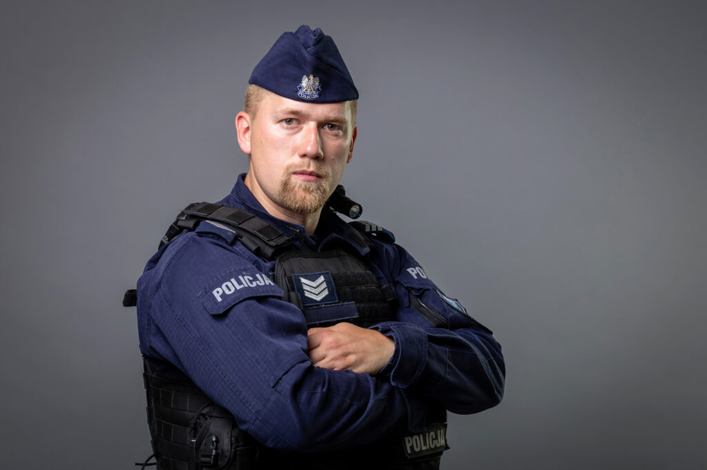portret mundurowy, policja, policjant. mundur służbowy z czapką, kamizelka taktyczna