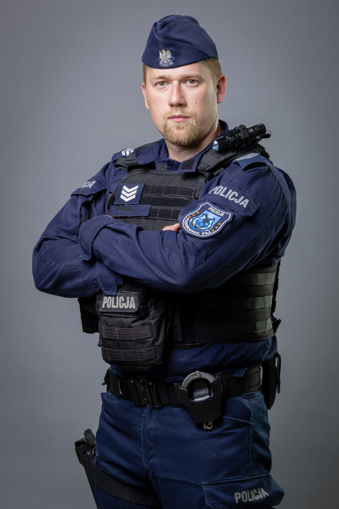 portret mundurowy, policja, policjant. mundur służbowy z czapką, kamizelka taktyczna
