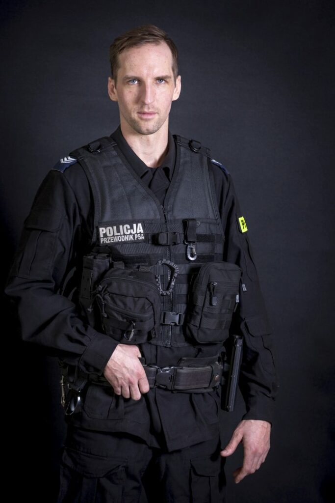 portret mundurowy, policja, policjant, mundur służbowy czarny bez czapki, kamizelka taktyczna